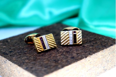  Botões de punho em ouro com diamantes em talhe brilhante e rubis calibrados.